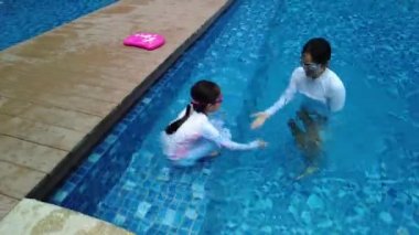 Havuzda yüzen genç kadın ve kız, yaz tatili konsepti.