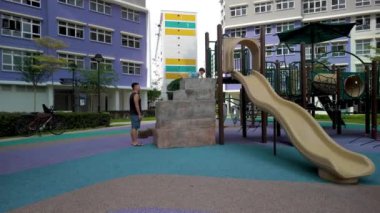 Yeni HDB 'lerle oynayan çocukları barındıran konutların arasında oyun parkı olan Singapur manzarası
