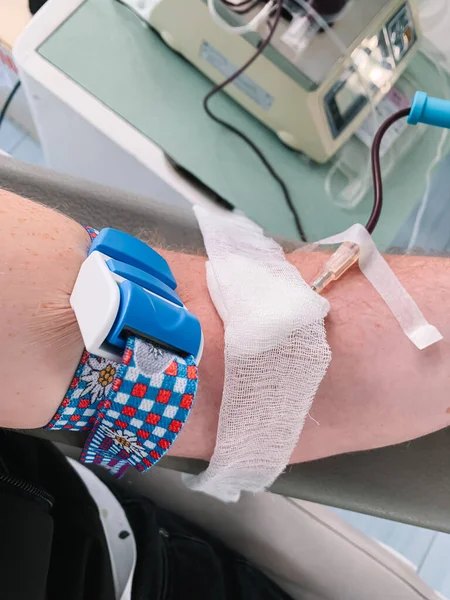 stock image Blood donor at donation, transfusion. Close up right arm of a business man receiving blood in hospital. Healthcare and charity. World blood donor day - June 14