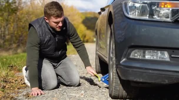 Adam Patlamış Lastiği Değiştirmek Için Jack Üzerine Araba Kaldırıyor Yolda — Stok video
