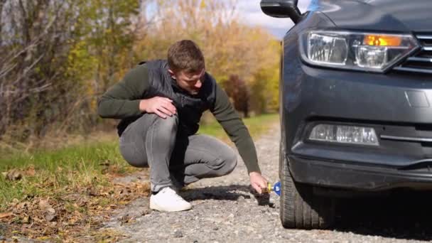 Adam Patlamış Lastiği Değiştirmek Için Jack Üzerine Araba Kaldırıyor Yolda — Stok video
