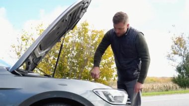 Otomatik arıza kaza denetimi yağ seviyesi. Araç motor yağı seviyesini kontrol et. Araba motoru aşırı ısınıyor. Bozuk araba kazası geçiren üzgün bir adam. Motor kapağını aç. Ulaşım, seyahat kavramı