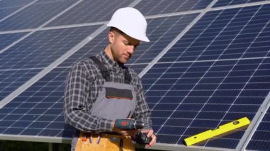 Erkek mühendis güneş panelleri kurmak için araçları hazırlıyor.