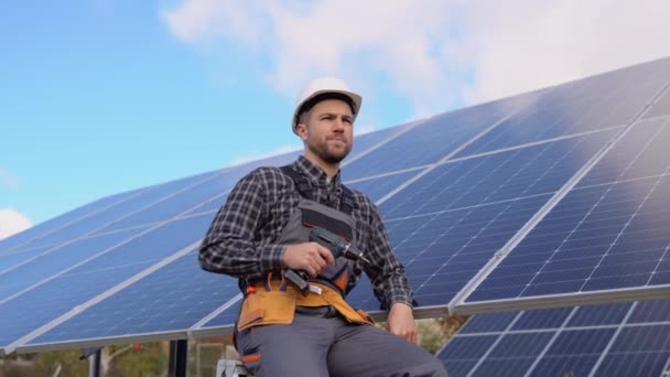 太阳能电池农场行业自信工程师的肖像 站在太阳能电池板附近的戴防护头盔的男工的近照 — 图库视频影像