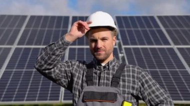 Solar power plant. Man standing near solar panels. Renewable energy.