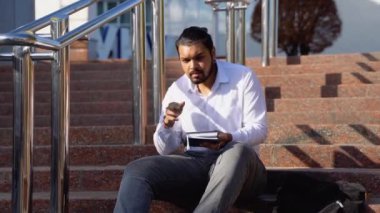 Üniversitenin yanındaki mutlu Hintli erkek öğrenci.