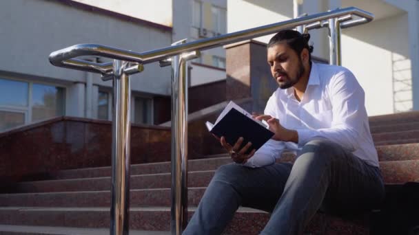 Joven Estudiante Indio Sienta Los Escalones Lee Libros — Vídeo de stock