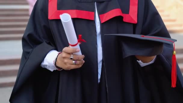 身穿毕业礼服的印度男子的近照 手持毕业文凭和帽子 — 图库视频影像