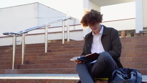 Jovem Estudante Encaracolado Ruivo Senta Nas Escadas Livros Campus Universitário — Vídeo de Stock