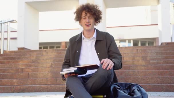 幸せなハンサムな成功した学生ブレースで 階段や笑顔に座って 大学の近くの路上で屋外のフレームを見て — ストック動画