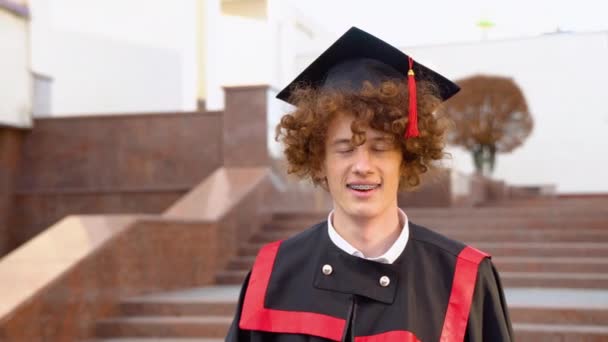 Niski Kąt Portret Szczęśliwego Triumfalnego Absolwenta Stojącego Pobliżu Uniwersytetu Trzymającego — Wideo stockowe