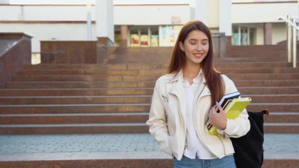 Chica Estudiante Feliz Posando Con Mochila Sosteniendo Libros Sonriendo Mirando — Vídeo de stock