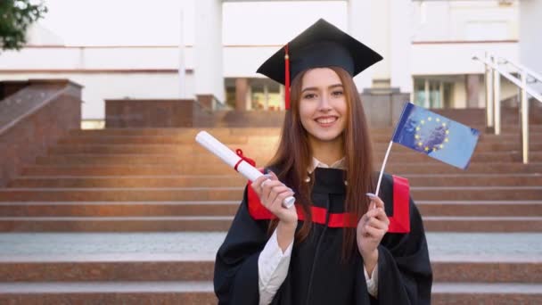 Lulusan Master Memegang Ijazah Pendidikan Tinggi Dan Bendera Uni Eropa — Stok Video