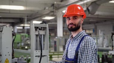 Fabrika atölyesinde makine kullanan akıllı bir fabrika işçisi. Endüstri ve mühendislik kavramı.