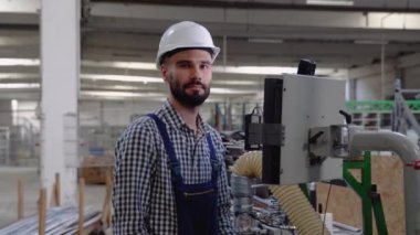 Makine operatörü. Fabrikada güvenlik üniforması ve kask giyen endüstriyel işçiler..