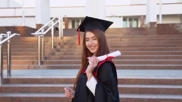 Una Graduada Universitaria Levanta Manto Maestros Elegantemente Sostiene Diploma Hombro — Vídeos de Stock
