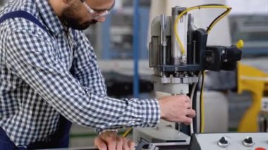 Fabrika atölyesinde makine kullanan akıllı bir fabrika işçisi. Endüstri ve mühendislik kavramı.