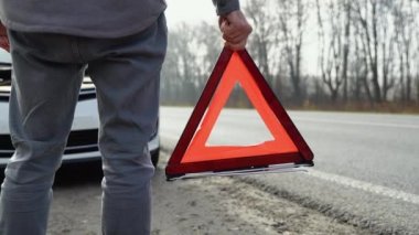 Sisli bir yolda kırmızı üçgenli bir adam