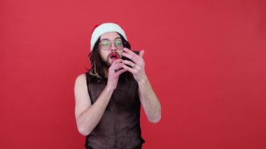 Parlak pembe bluzlu, genç ve seksi Latin eşcinsel adam mor arka planda izole edilmiş ruj lekeli bayrak boyalı dudaklarıyla elini kaldırsın. Insanlar yaşam tarzı lgbtq konsepti.
