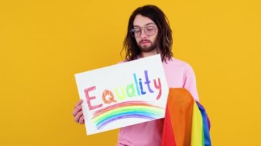 Çekici sakallı beyaz bir adam LGBT geçit töreni sırasında protesto işareti tutuyor. Aşk aşktır.