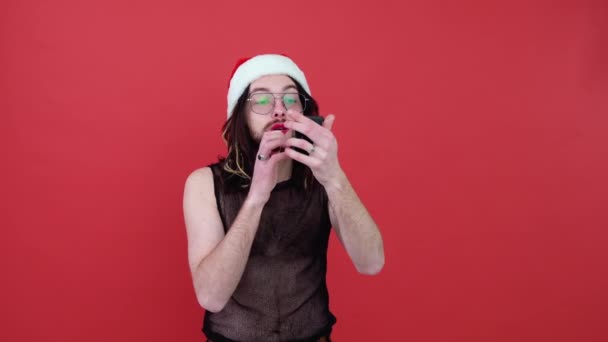 Νεαρός Σέξι Γκέι Άντρας Καπέλο Σάντα Ζωγραφίζει Χείλη Απομονωμένα Κόκκινο — Αρχείο Βίντεο