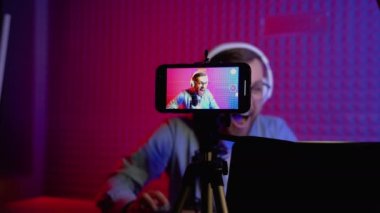 Profesyonel siber oyuncunun canlı yayını, akıllı telefonla video oyunu oynarken video kaydı. Neon rengi arkaplanı