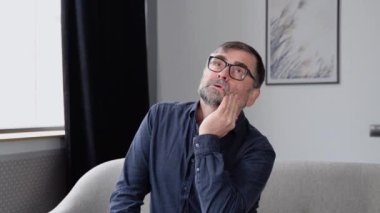 Son sınıf yakışıklısı diş ağrısı ya da diş hastalığından dolayı eli ağrılı bir şekilde ağzına dokunuyor. Dişçi konsepti