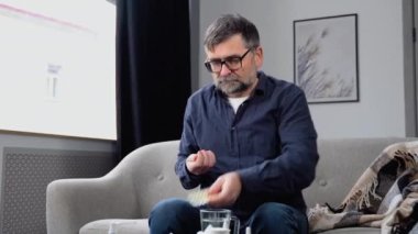 Hasta bir adam soğuk algınlığı hapı içer - evde tedavi