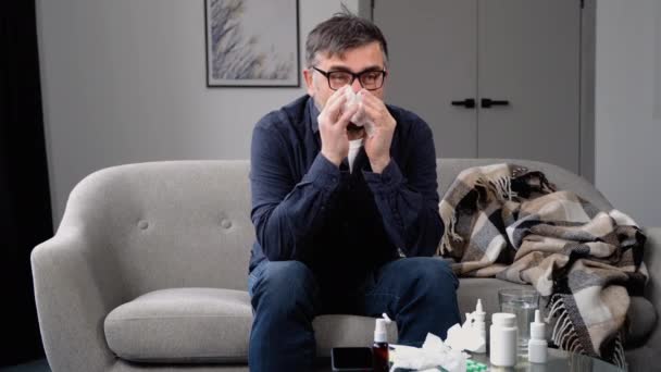 Homem Congelado Doente Senta Sofá Usa Chapéu Segura Tecido Soprando — Vídeo de Stock
