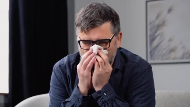 生病的冻人坐在沙发上 戴着帽子 拿着纸巾吹着流鼻涕发烧 感冒了 附近有一堆药 季节性流感症状 无发热扁平概念 — 图库视频影像