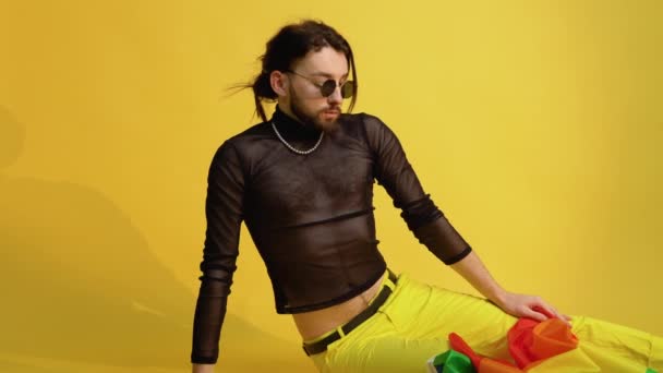 Gay Muž Oblečený Síťovaném Tričku Sedí Žlutém Pozadí Pestrobarevnou Vlajkou — Stock video
