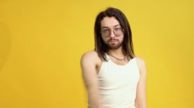 Sarı arka planda gökkuşağı bayrağı taşıyan adam. Gay gurur konsepti
