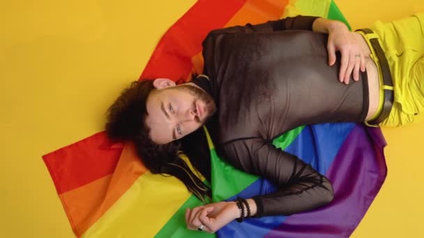 Young Caucasian Gay Man Rainbow Striped Flag Lies Yellow Background — Stock Video