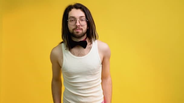 一个穿着白色T恤 粉色裤子和黄色背景领结的年轻基佬的画像 — 图库视频影像