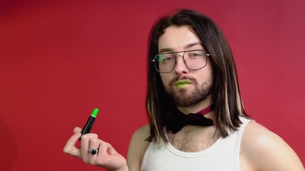 Νέοι Σέξι Γκέι Άντρας Ζωγραφίζει Χείλη Πράσινο Κραγιόν Απομονώνονται Κόκκινο — Αρχείο Βίντεο