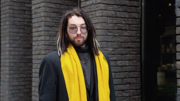 コートと黄色のスカーフの外に若い白人のスタイリッシュな男の肖像画 — ストック動画