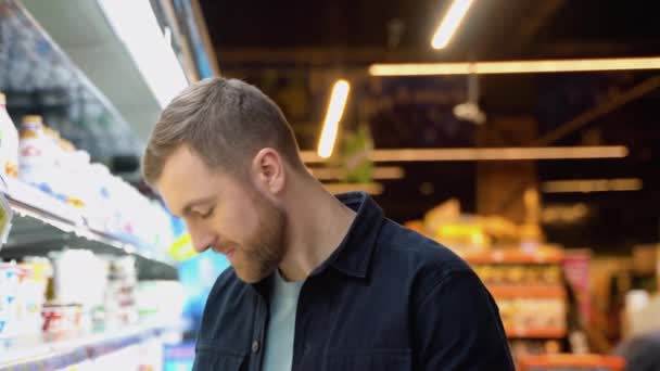 若い幸せな明るい正の笑顔男性の顧客は 食料品 家族のショッピングで牛乳や乳製品を選択 — ストック動画
