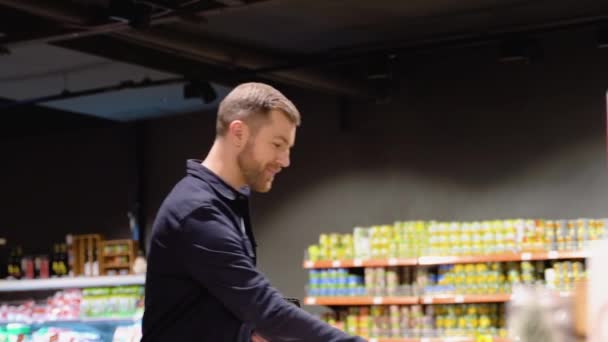 Mladý Muž Vybírá Lilek Supermarketu Výběr Potravin Police Supermarketu — Stock video