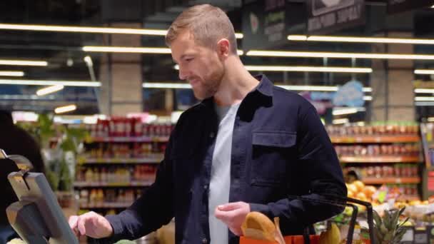 Einkaufen Verkaufen Konsumieren Junger Mann Wiegt Brokkoli Auf Waage Supermarkt — Stockvideo