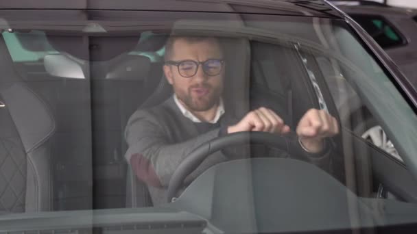 Seorang Pria Bergaya Bahagia Mengendarai Mobil Listrik Mewah Baru Dealer — Stok Video