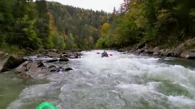 Kayıklı bir adam dağ nehrinde yelken açıyor. Beyazsu kayağı, ekstrem kayak.