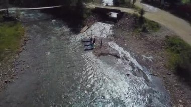 Tecrübeli bir antrenör, dağ nehrinin kıyısında rafting yapmadan önce eğitim veriyor.