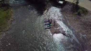 Tecrübeli bir antrenör, dağ nehrinin kıyısında rafting yapmadan önce eğitim veriyor..