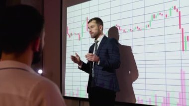 Presentation Event: businessman talks of sales growth in the stock market showing TV big data statistics, charts, revenue growth infographics. Press conference for digital entrepreneurs, investors