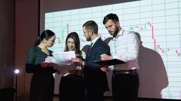 株式市場のチャートを背景に オフィスで会うビジネスマンのグループ ビジネスと技術の概念 金融技術 フィンテック — ストック動画
