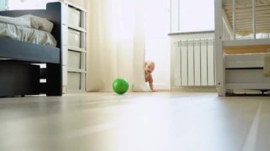 Crawling funny baby girl indoors at home. Childhood concept