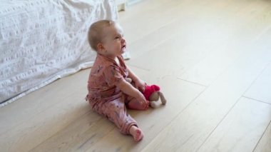 Baby girl playing with toy indoors at home. Childhood concept