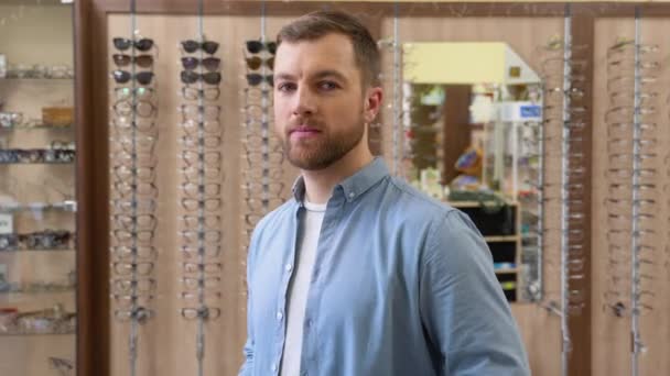 Mladý Muž Vybírá Brýle Obchodě Optikou — Stock video