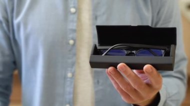 Close -up man holds a case with glasses in optics