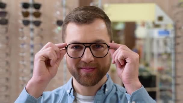 Portrait Handsome Bearded Guy Picking New Specs Optical Shop Choosing — Vídeo de Stock